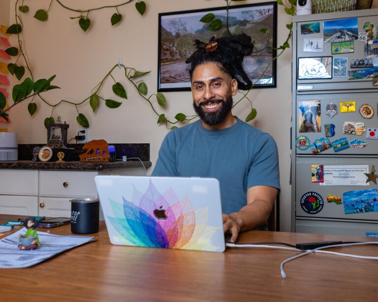 Carlos working at his desk with a MacBook