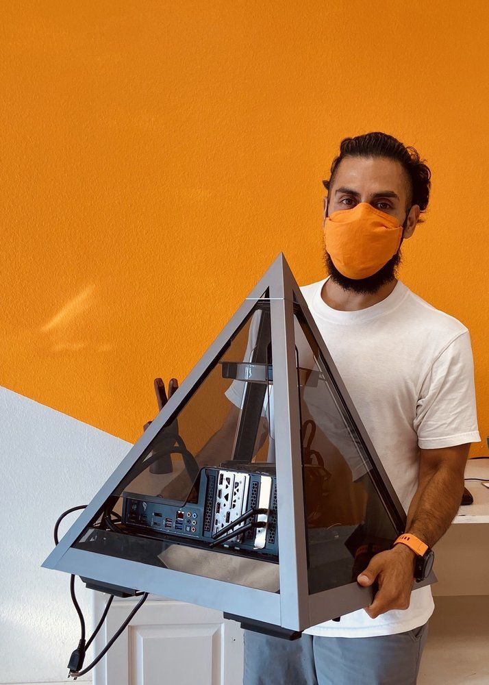 Carlos holding a custom pyramid-shaped PC build